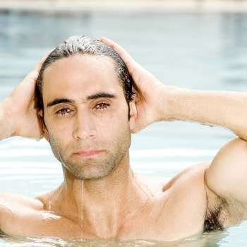 Portrait of a mid adult man with his hands on his head in a swimming pool
