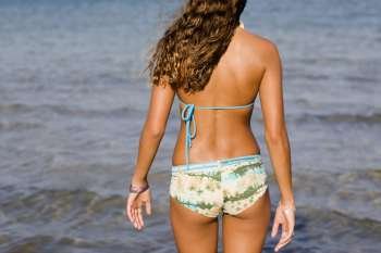 Rear view of a teenage girl standing on the beach