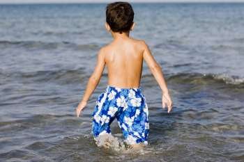 Rear view of a boy walking in water