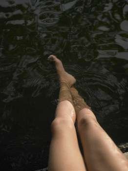 High angle view of woman´s legs in water