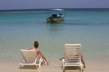 Tourists sitting on the beach chairs, West Bay Beach, Roatan, Bay Islands, Honduras