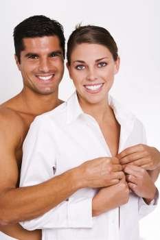 Portrait of a mid adult man buttoning a young woman´s shirt