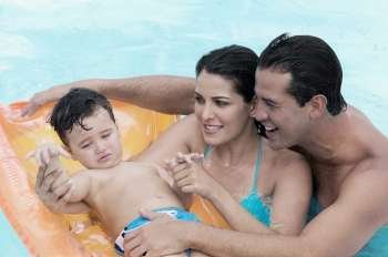 Close-up of parents with their son in a swimming pool