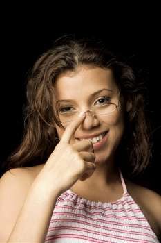 Portrait of a teenage girl adjusting her eyeglasses