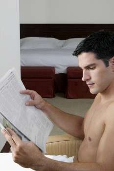 Side profile of a young man reading a newspaper