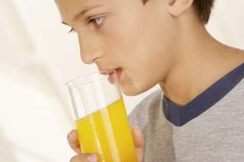 Close-up of a boy holding a glass of orange juice
