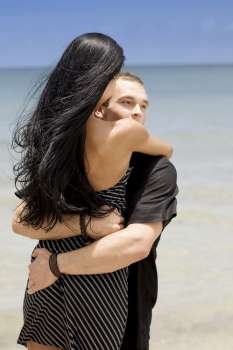 Close-up of a young couple embracing each other on the beach