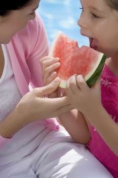 Close-up of a girl eating a slice of watermelon