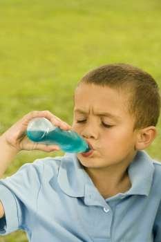 Close-up of a boy drinking beverage from a bottle