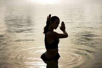 High angle view of a young woman exercising in a lake