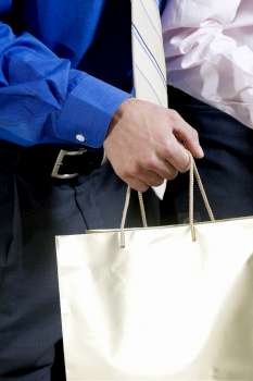 Mid section view of two businessmen holding shopping bags