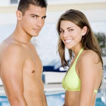 Portrait of a young couple standing at the poolside