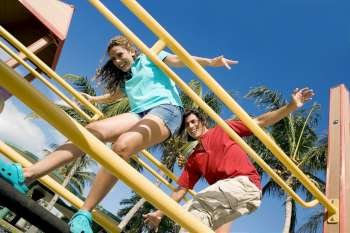 Low angle view of a mid adult couple standing on a jungle gym and smiling