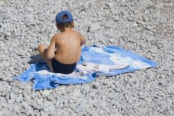 Rear view of a boy sitting on a blanket, Capri, Campania, Italy