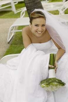 Portrait of a bride holding a bouquet of flowers and smiling