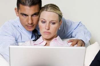 Close-up of a young woman and a young man looking at a laptop