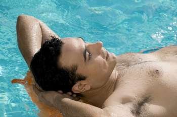 Close-up of a young man lying on a raft in a swimming pool