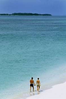 Rear view of a couple taking a stroll on a seashore, Paradise Island, Nassau, Bahamas