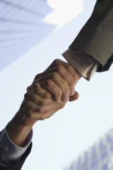 Low angle view of two people shaking hands