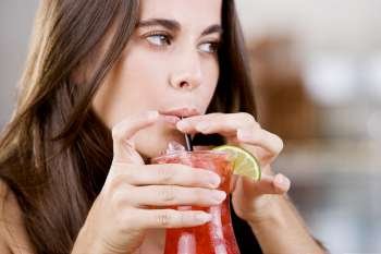 Close-up of a young woman drinking a cocktail