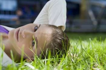 Portrait of a businesswoman lying on grass in a park