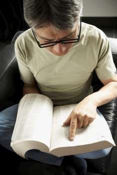 High angle view of a mature man reading a book