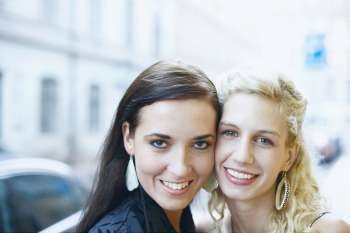Portrait of two young women standing cheek to cheek 