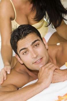 Mid adult woman massaging a mid adult man´s shoulders on the bed