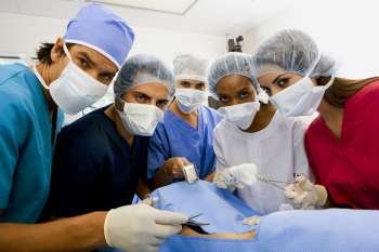 Portrait of three female surgeons and two male surgeons operating a patient