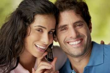 Portrait of a mid adult man and a young woman holding a mobile phone