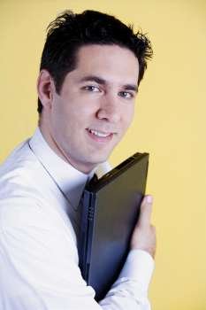 Portrait of a businessman holding a laptop and smiling