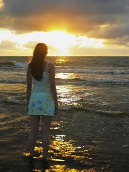 Rear view of a teenage girl standing on the beach