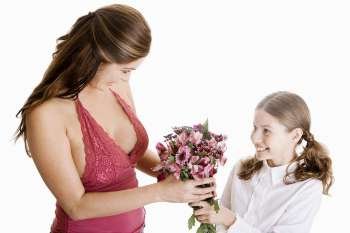 High angle view of a girl giving her mother a bunch of flowers