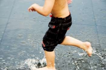 Low section view of a boy playing in water