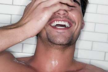 Close-up of a young man bathing and laughing