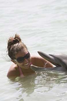 Teenage girl playing with a dolphin, Roatan, Bay Islands , Honduras