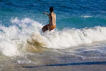 Rear view of a man on a surfboard, South Beach, Miami, Florida, USA