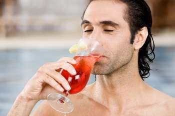 Close-up of a mid adult man drinking a cocktail