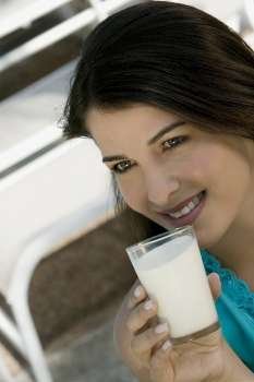 Close-up of a young woman holding a glass of milk