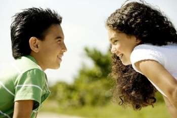 Close-up of a boy and a girl looking at each other smiling