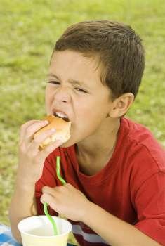 Close-up of a boy eating a burger