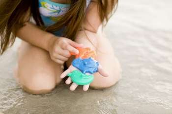 Mid section view of a girl playing with toys on the beach