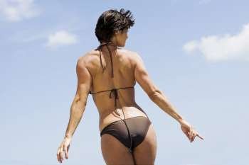 Rear view of a mid adult woman posing on the beach