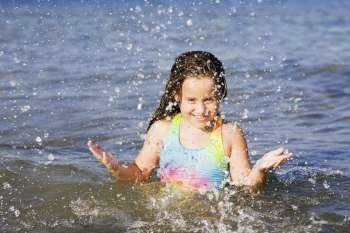 Portrait of a girl splashing water in the sea