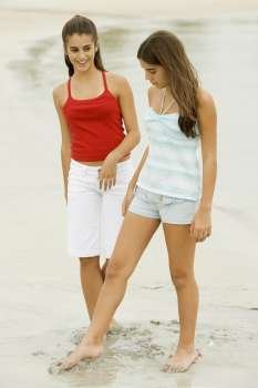 Two girls standing on the beach