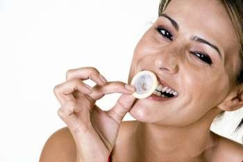 Portrait of a mid adult woman biting a condom