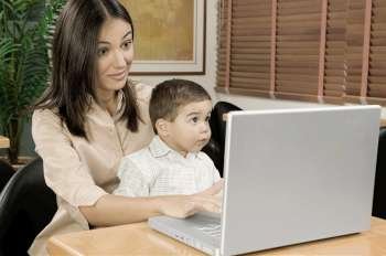 Mother using a laptop with her son