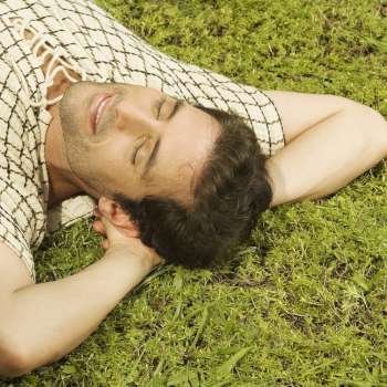 High angle view of a mid adult man sleeping on the grass