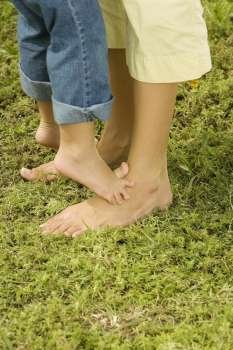 Low section view of a child feet on an adult´s feet