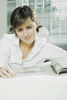 Close-up of a mid adult woman reading a magazine